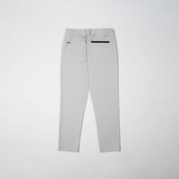 Poda project pants in limestone color, showing back zip pocket and logo patch